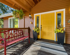 Large, covered front porch with sunny front door invites you in.