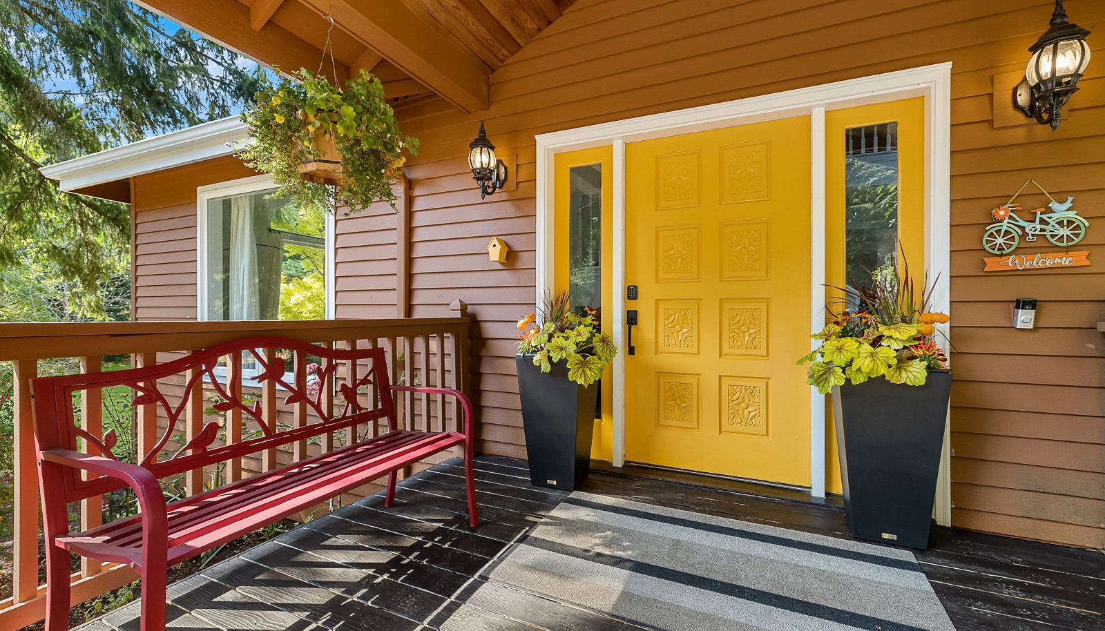 Large, covered front porch with sunny front door invites you in.