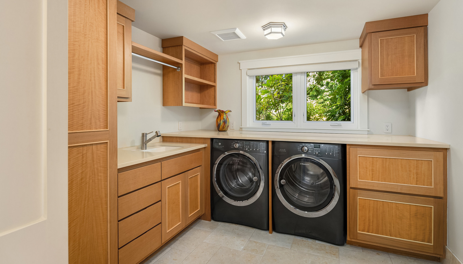 The lower level laundry room with sink, Anigre cabinets and plenty of counter space. 