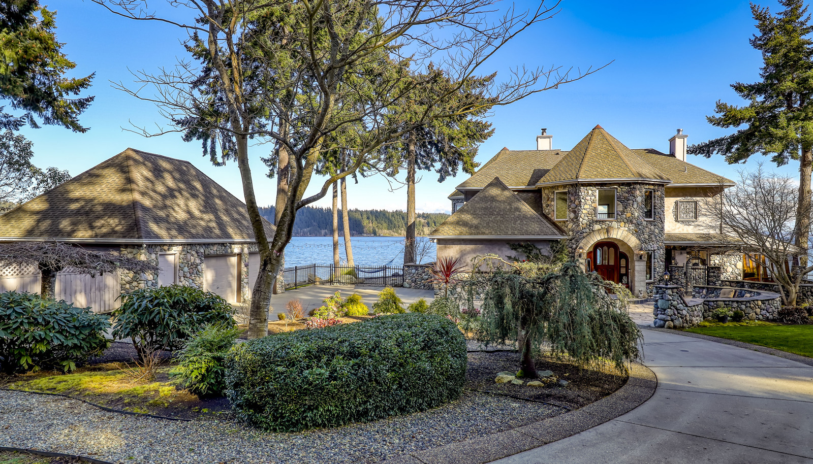 Circular drive, gorgeous landscaping, and water views in all directions!