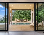 Oversized glass opens to covered PNW outdoors.