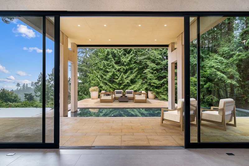 Oversized glass opens to covered PNW outdoors.