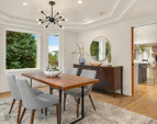 Dining room off the living room has bay windows and a tray ceiling creating an open atmosphere.