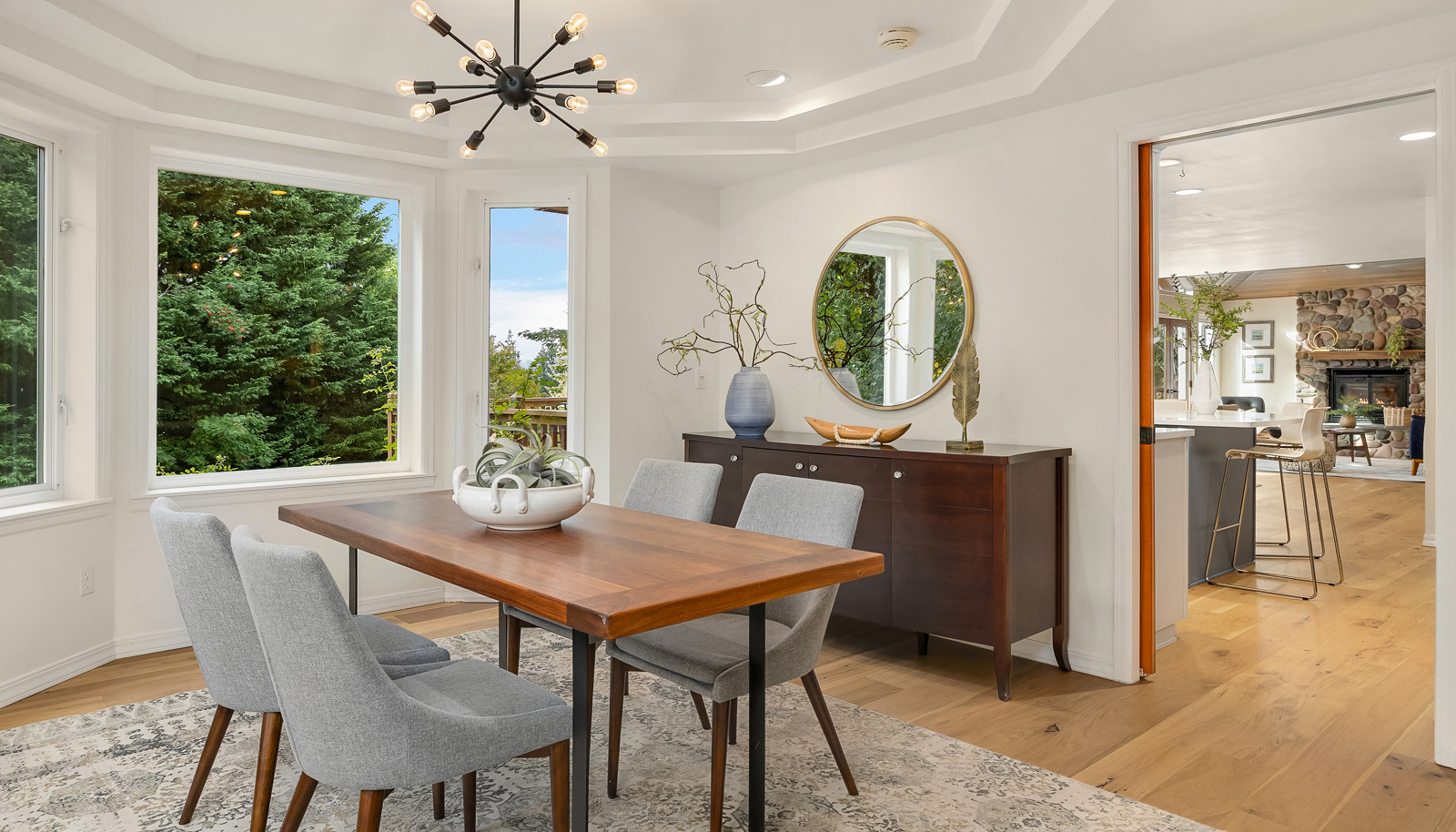 Dining room off the living room has bay windows and a tray ceiling creating an open atmosphere.