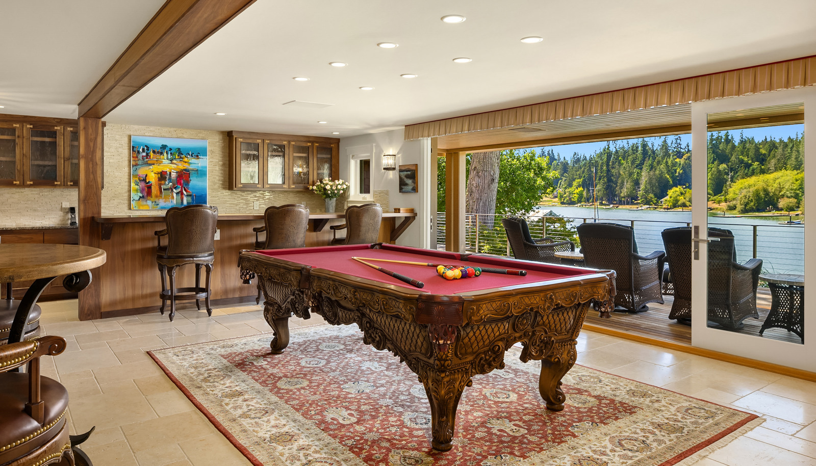 A major highlight of the home is the media/game room with bar, wine fridge and a wall of Nano Glass doors that open to a private, covered Ipe deck. 