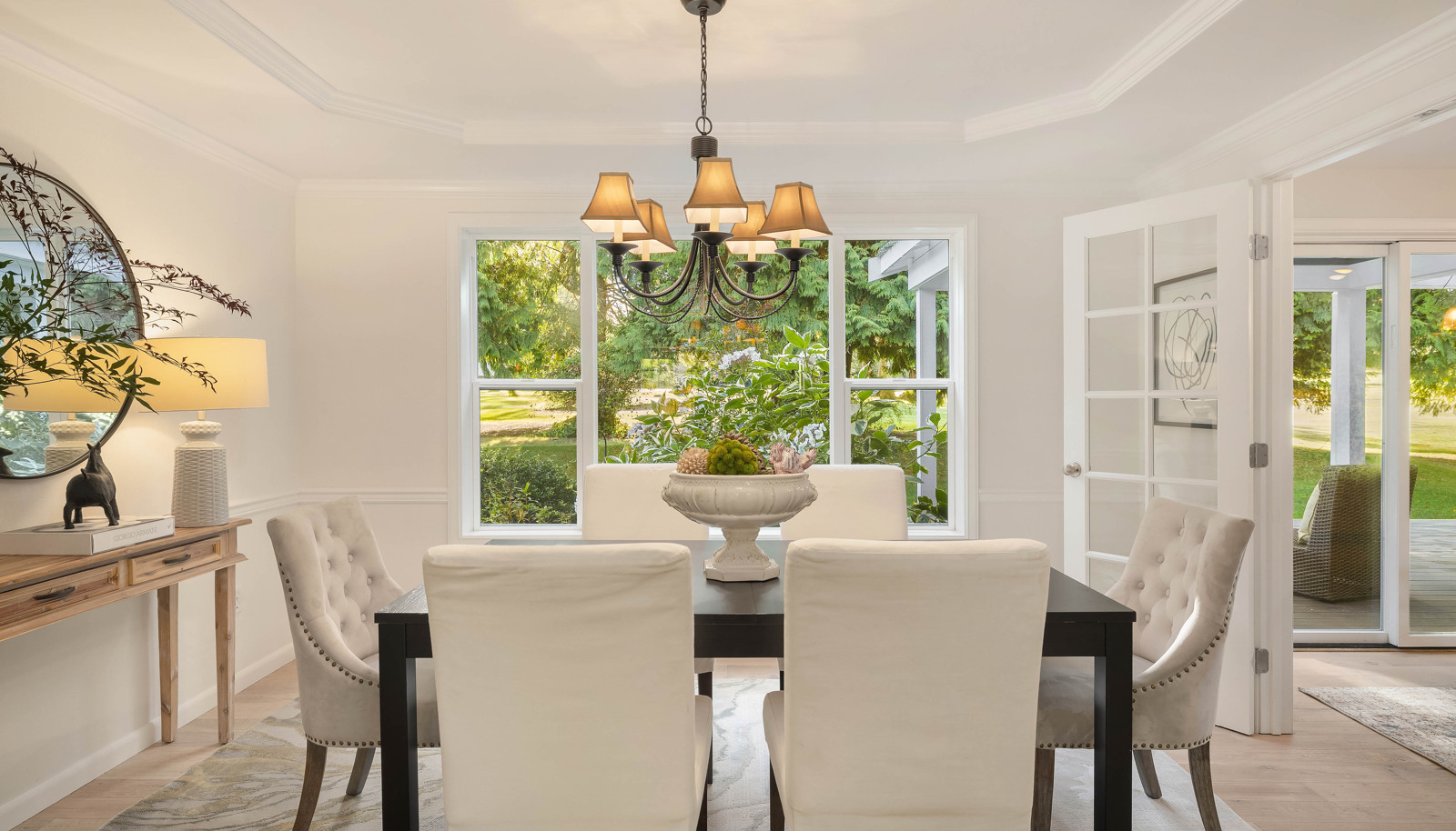 Dining room with view window to the backyard and gardens. Note the coffered ceiling and French doors!