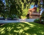 A serene setting with cedar trees, lawns and gardens. Convenience with a paved circular drive. The cottage is just to the left.